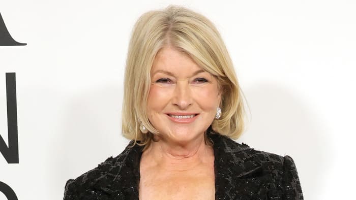 Martha Stewart poses in a sequined black blazer and smiles for the camera.
